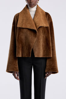 Model is wearing the Nour Hammour Cascade Draped Shearling Jacket Marigold - Front Closed