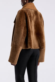 Model is wearing the Nour Hammour Cascade Draped Shearling Jacket Marigold - Back