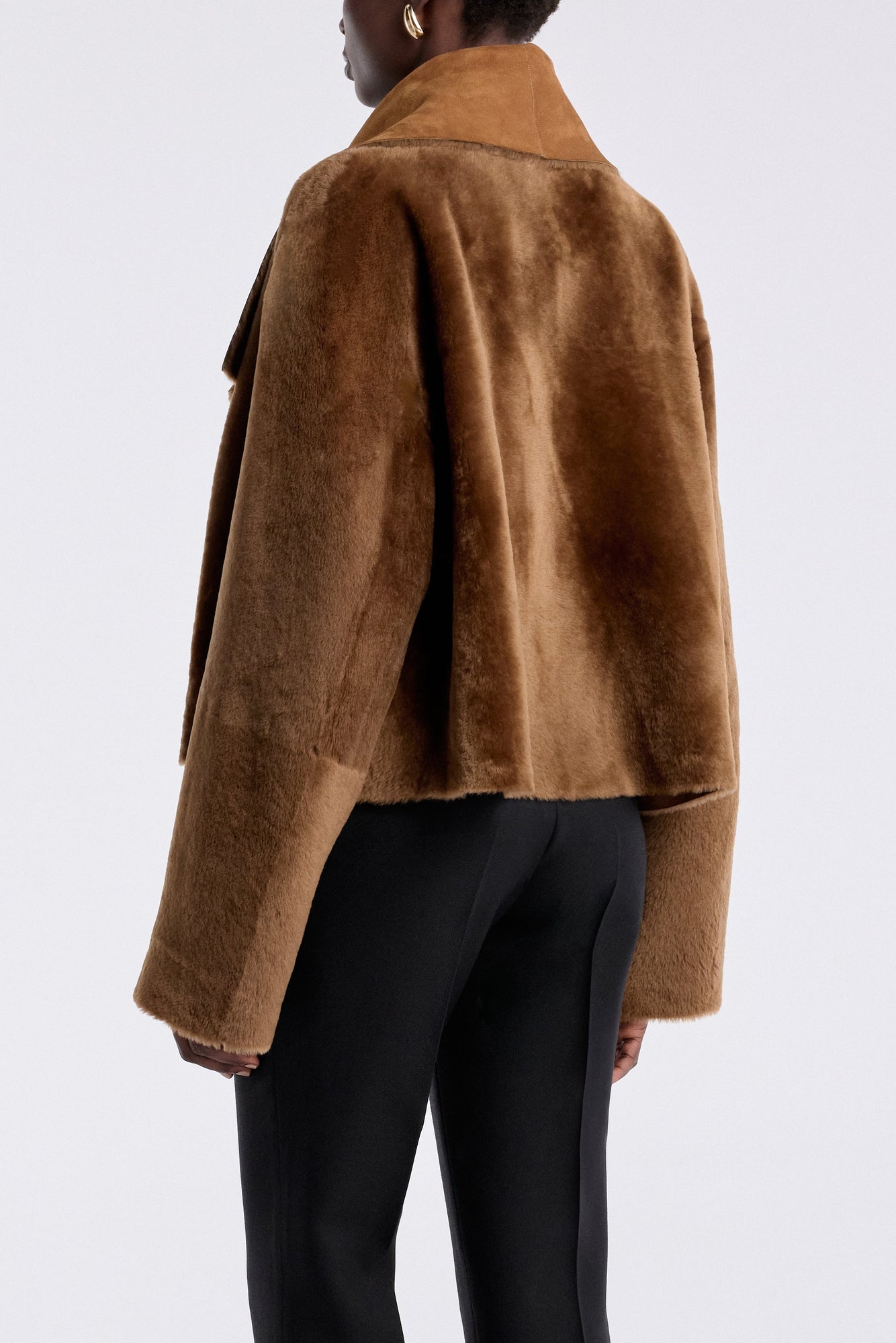 Model is wearing the Nour Hammour Cascade Draped Shearling Jacket Marigold - Back