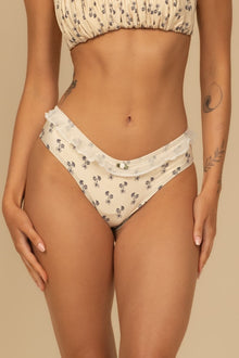 Cream bikini bottom with small dark floral print and ruffled waistband detail.