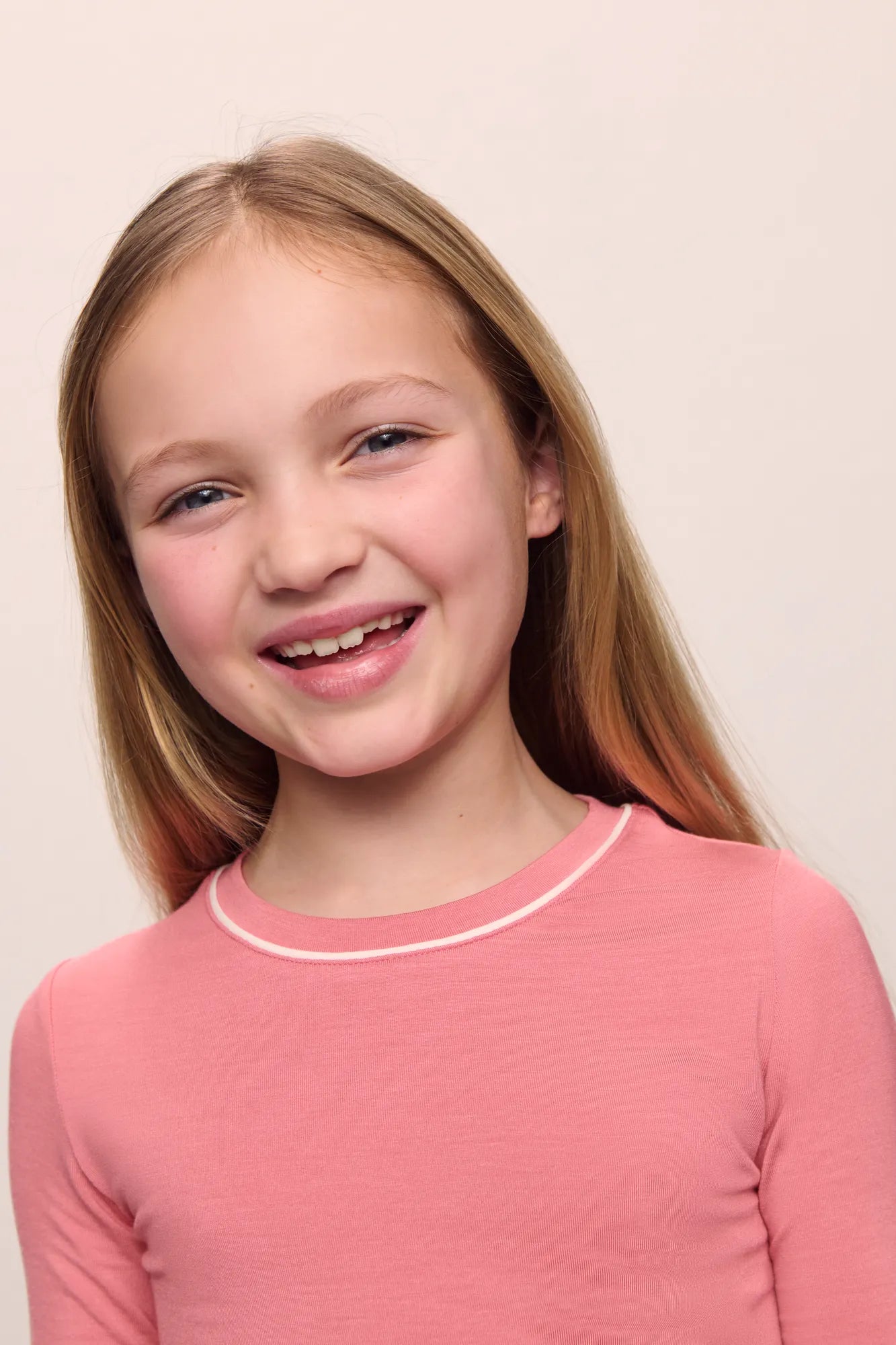 Model wearing Kids TENCEL Modal Unisex Long PJ Set in Sunkissed Coral/Ivory