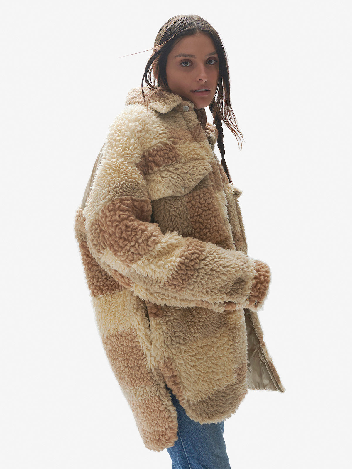 A female model wearing a beige and brown oversized wool sherpa shirt jacket with chest pockets and snap front closure.