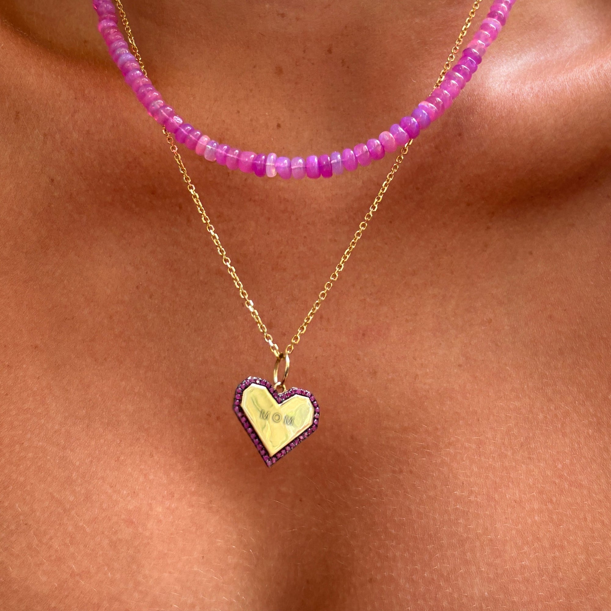 heat charm with rubies and "mom" engraving, styled with a fuchsia opal necklace.