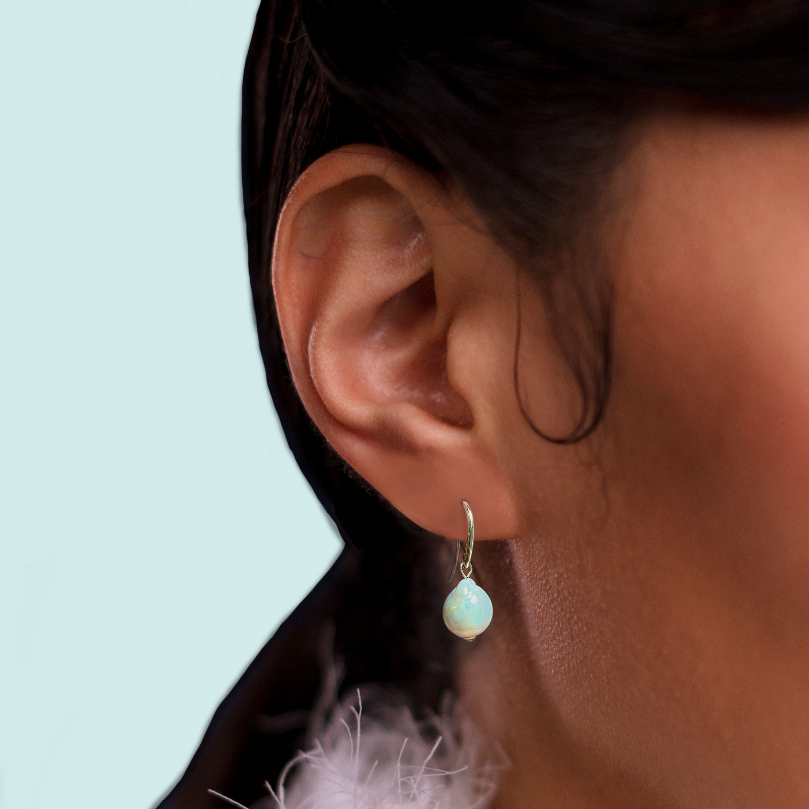 14k gold Mini Baroque Pearl Drop Earrings styled on a ear.