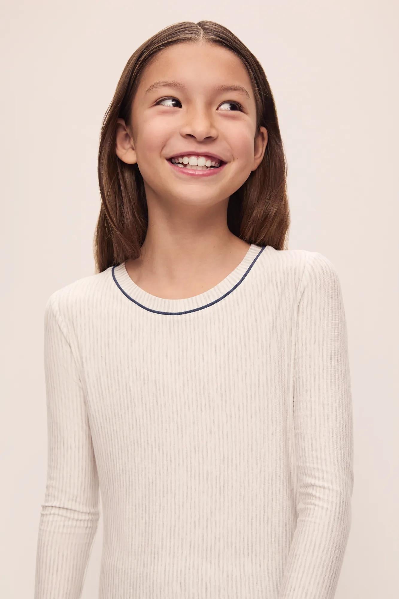 Model is wearing Kids Printed TENCEL Modal Unisex Long PJ Set in Heritage Stripe Light Heather Grey/Peppercorn