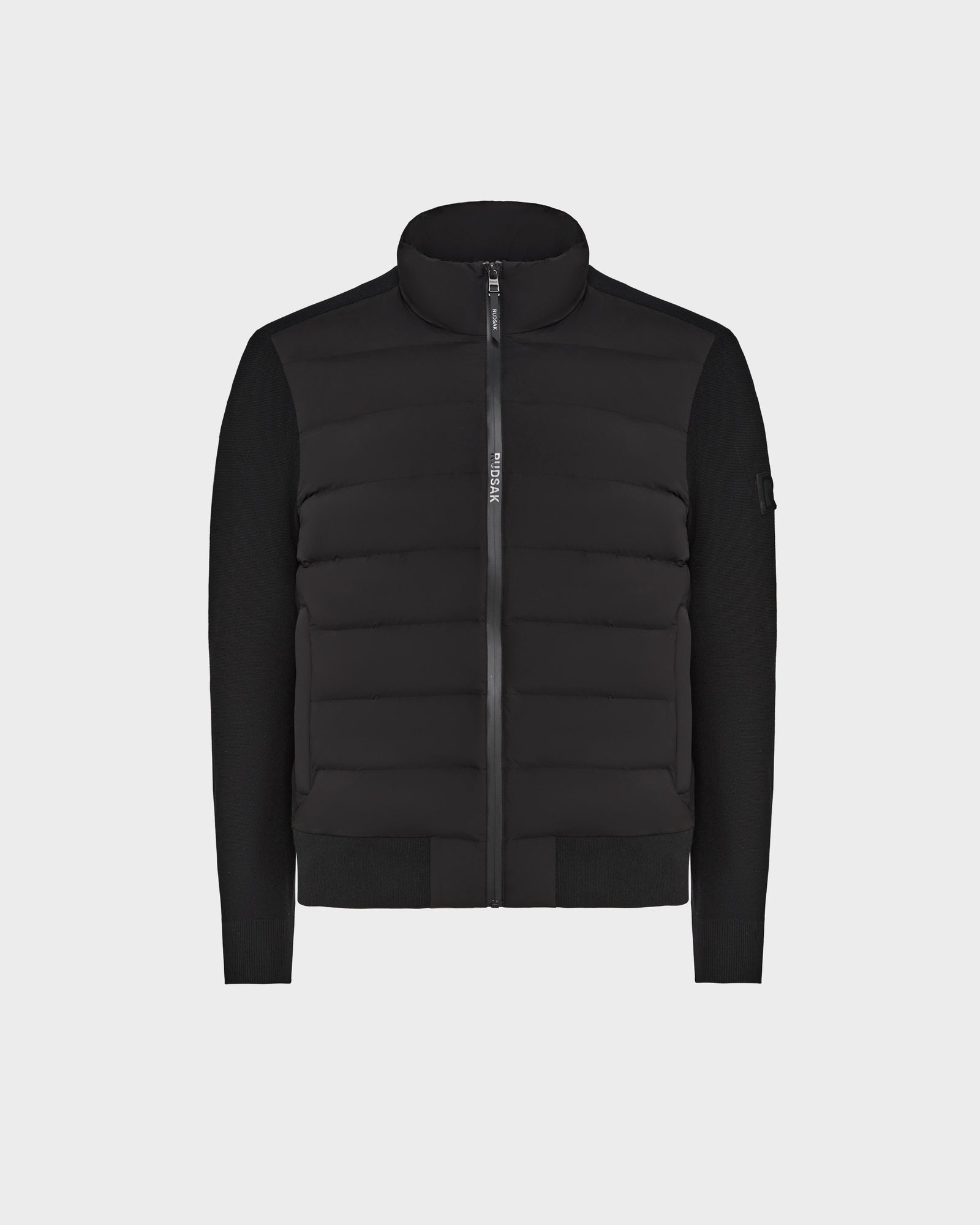 The Rudsak EUGENE - 6124016 Black is a mens hybrid jacket with a quilted front panel, high collar, smooth long sleeves, and lightweight zip-up design, shown against a plain light background.