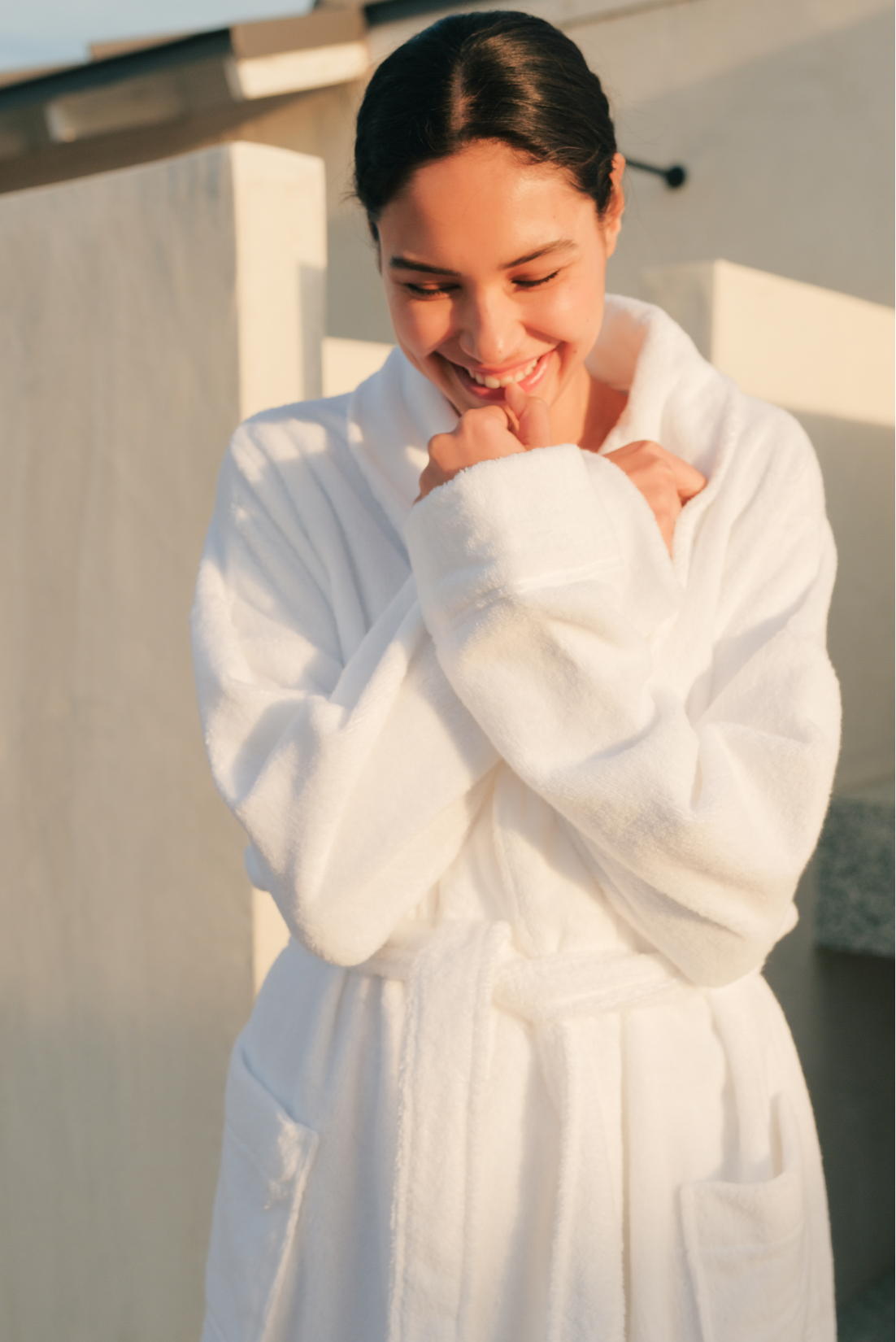 Model wears Terry Gender Neutral Robe in white.