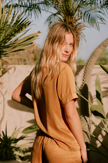 Model wears Inez Washable Silk Short PJ Set in rose powder caramel/burnt orange.