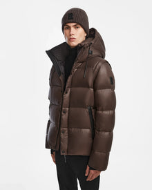 A man wearing the Rudsak BOBBY - 6124506 Espresso 2-in-1 jacket vest and a hat.