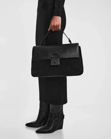 A person holding the Rudsak ESMA - 8324519 Black handbag, crafted from suede and leather.