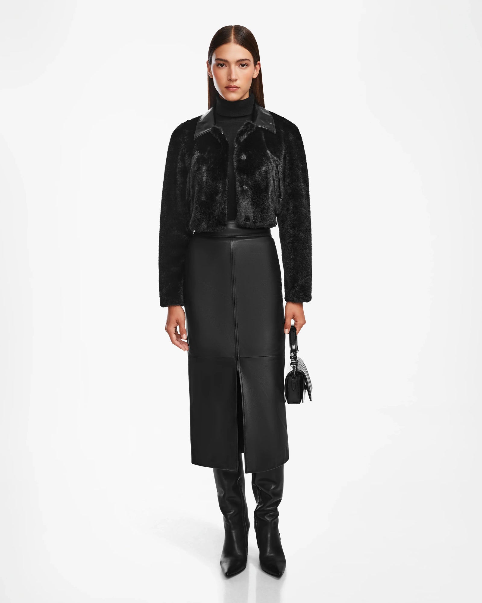 A woman in the EVELYN - 8124791 Black jacket by Rudsak exudes modern elegance, effortlessly showcasing luxurious outerwear.