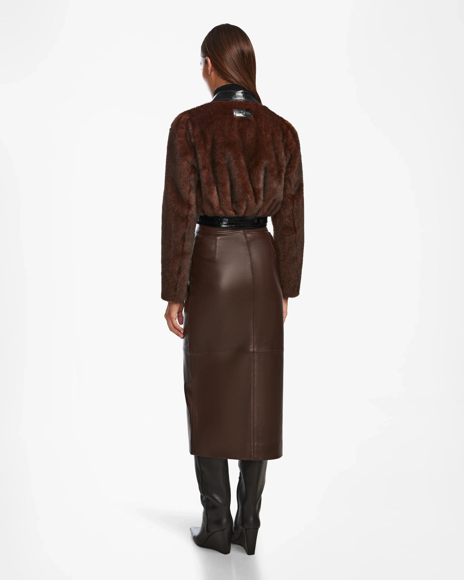 A woman pairs her brown skirt and boots with the chic EVELYN - 8124791 Espresso faux fur jacket by Rudsak.
