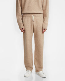 A person models the Rudsak GEIGER - 9524512 Camel M knit sweater and relaxed lounge pants with white sneakers, standing against a plain white background for a cozy and relaxed look.