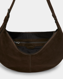 A close-up of the Rudsak LANISSA S - 8324520 Espresso shows an open dark brown suede hobo bag with a zipper closure, spacious black interior, and inner zippered pocket. This minimalist everyday bag blends style and function.