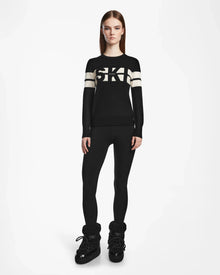 A woman wearing the ODESSA - 8523540 Black crewneck sweater and black pants by Rudsak, ideal for cozy winter warmth.