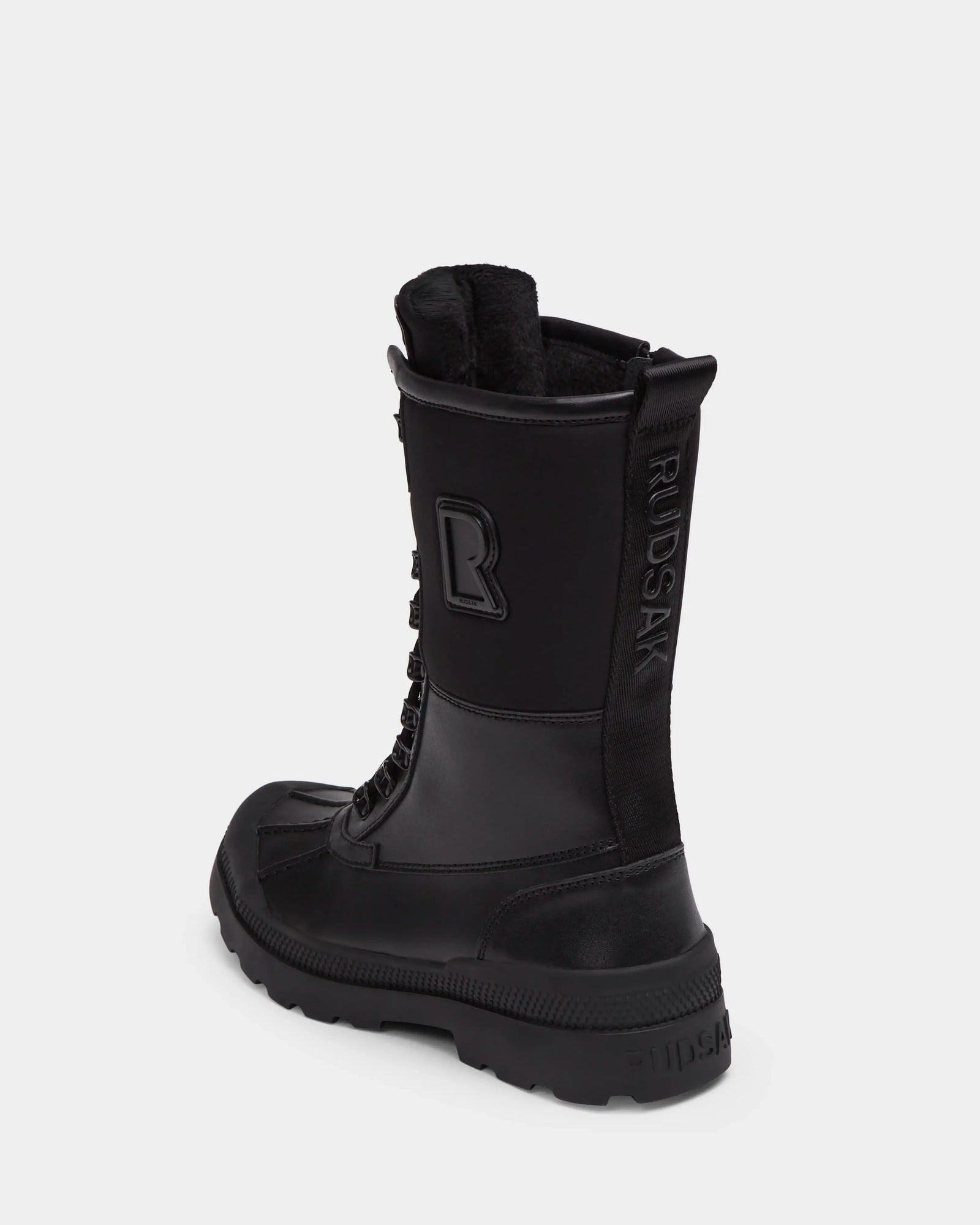 The Rudsak RITA - L222502 Black is a women’s black high-top winter boot with weather-treated leather, thick rubber sole, visible laces, and embossed branding on the side and back heel, displayed on a plain white background.