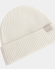 The ANDREY - U425507 Vanilla by Rudsak is a cream ribbed knit unisex beanie with a folded brim and a small rectangular RUDSAK tag on the cuff.