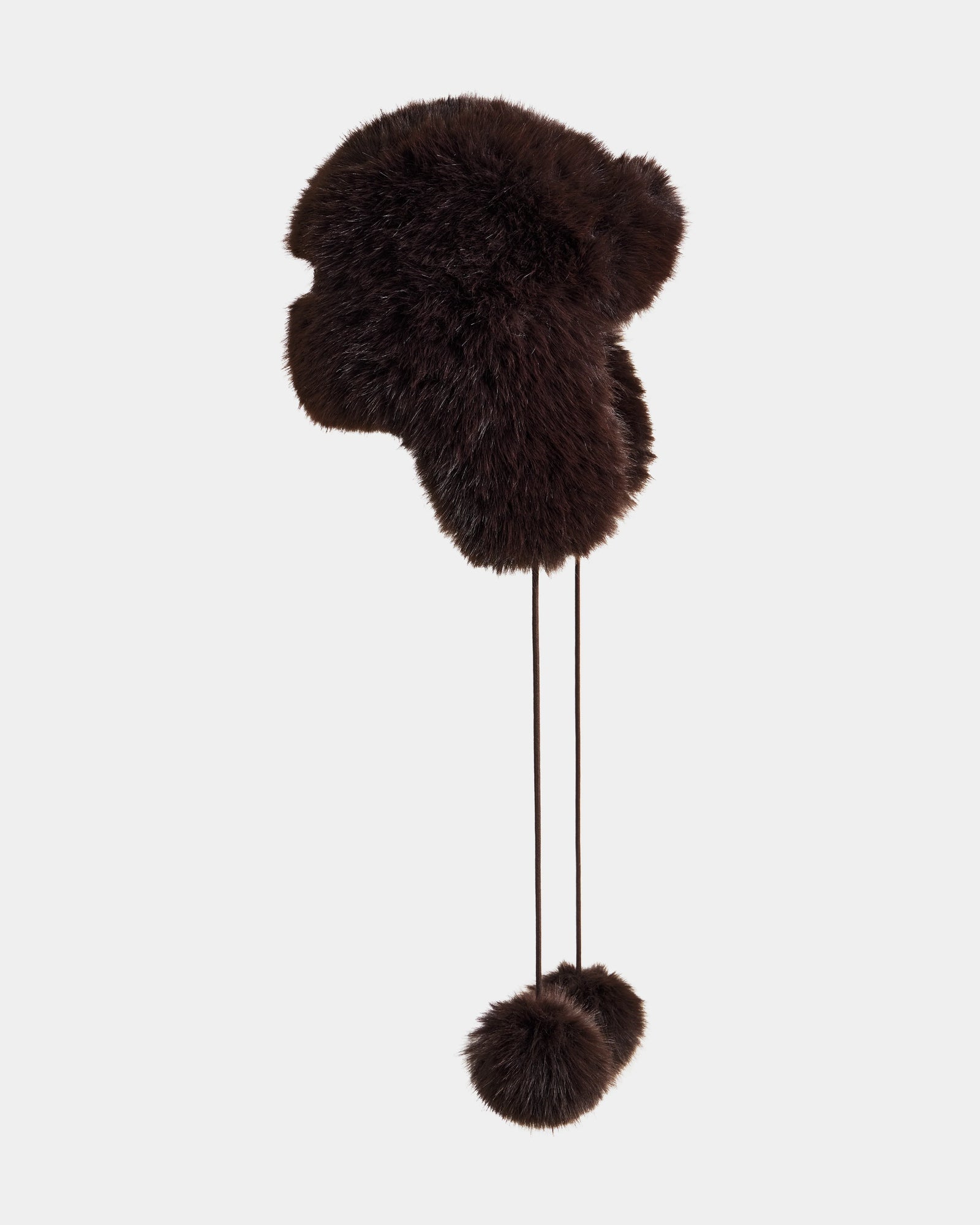 The DEMI - L425539 Espresso by Rudsak is a women's dark brown faux-fur aviator hat with ear flaps and two pom-poms on strings, shown against a plain light gray background.