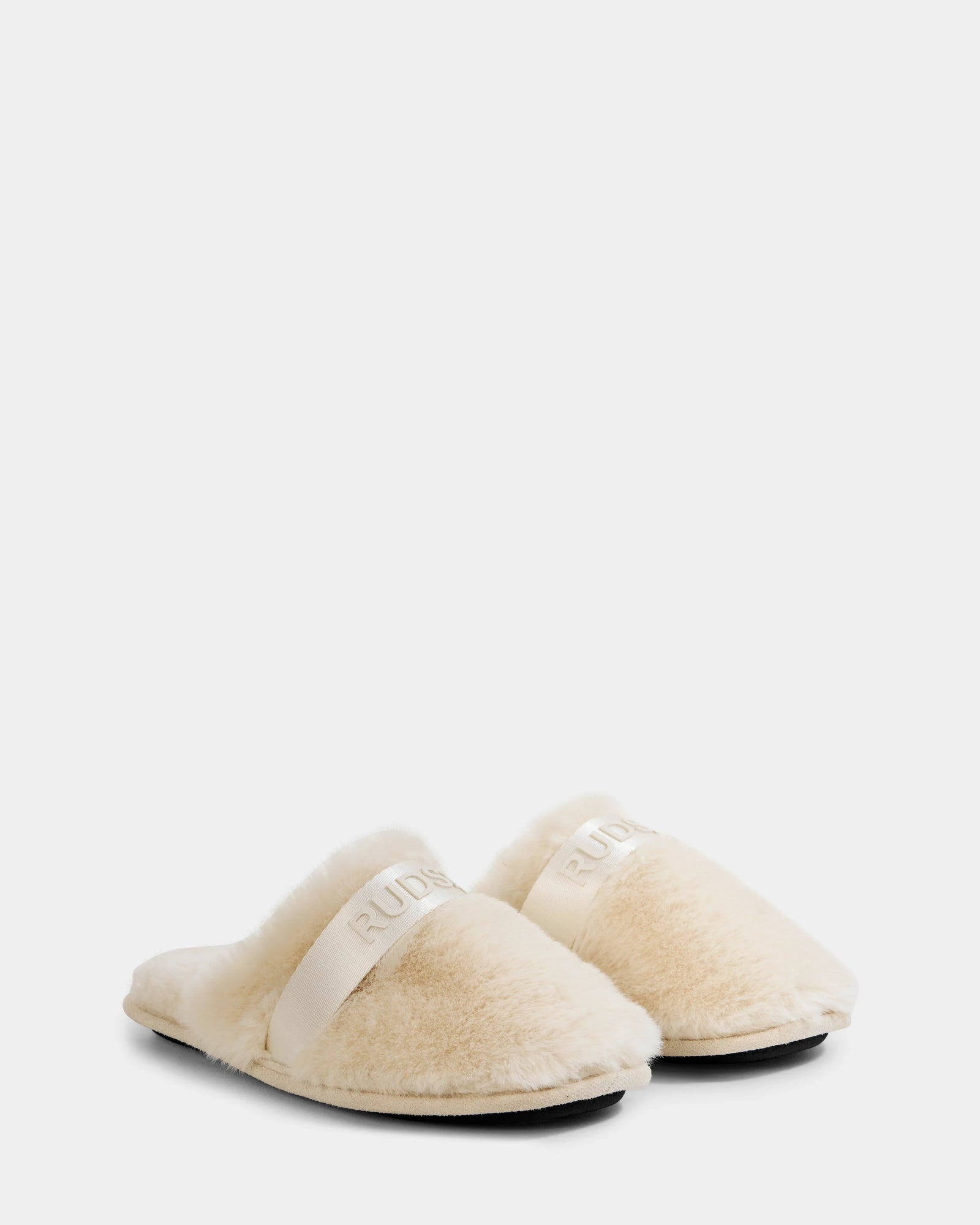 A pair of FLUFF - L223509 Cream women’s slippers by Rudsak, featuring cream-colored faux fur, open backs, thick soles, and a wide band across the top with “RUBINACCI” embroidered in white.