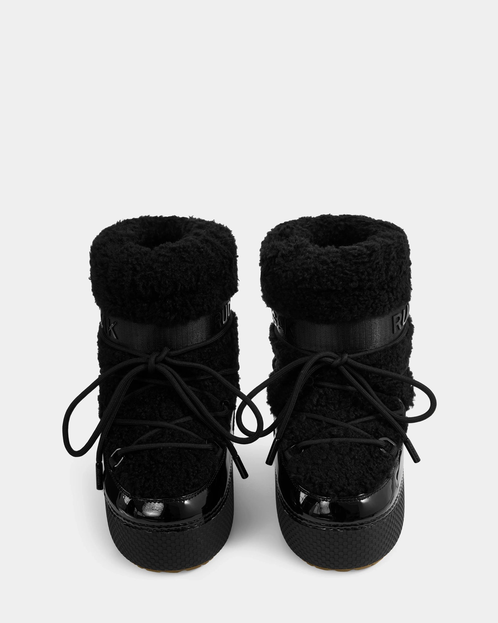 The KATHY Y - 1224500 Black winter boots by Rudsak feature a water-repellent, fuzzy textured upper, thick soles, and black laces, shown from the front against a white background.