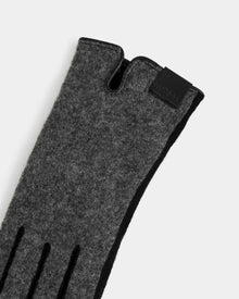 A close-up of the Rudsak OLGA - L425541 Grey women’s wool glove, featuring black detailing and a leather label by the wrist—an essential for style and warmth, shown against a plain light background.