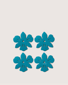 Four blue, flat flower cutouts by Graf Lantz—crafted from premium German Merino wool—are arranged in a grid on a plain white background, making these coasters both sustainable and biodegradable.