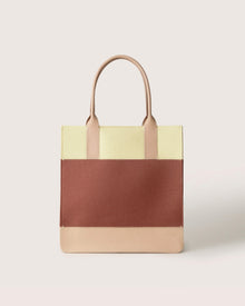 The Graf Lantz Jaunt Midi Tote is a stylish color-block handbag in cream, brown, and beige Merino wool. It features two beige handles and a minimalist look, ideal as a mid-size carryall.