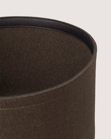 Close-up of the upper edge of a Graf Lantz brown cylindrical object with a soft, textured surface and smooth black inner lining, possibly the inside of a hat or storage container, set against a light background.