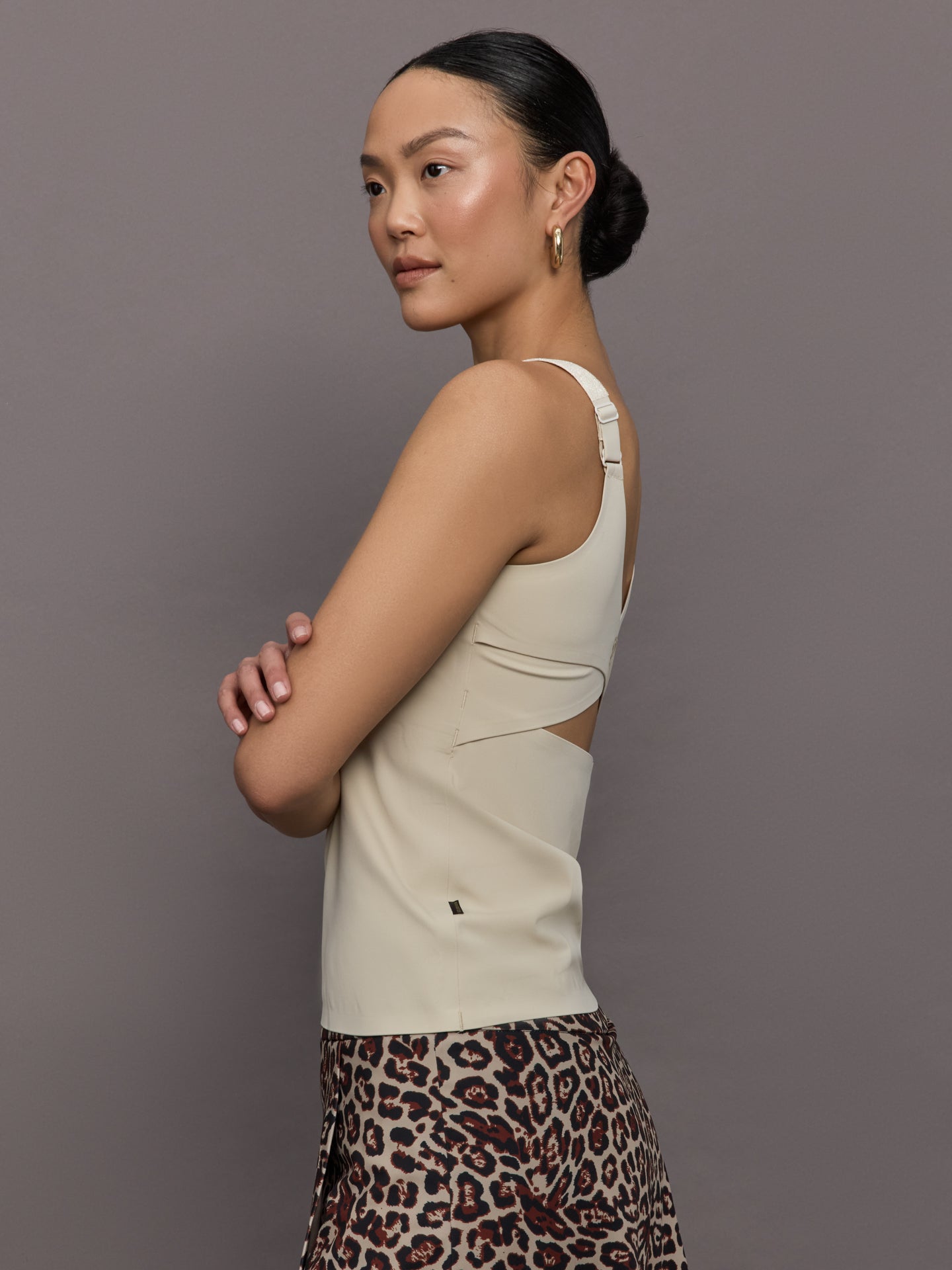 Model wears a neutral colored tank top. 