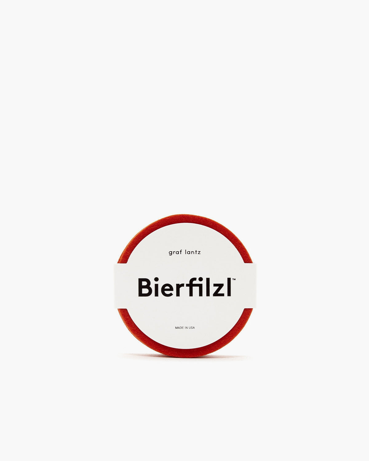 A round red felt coaster made from German Merino wool by graf lantz. It has a clean white label in the center with Bierfilzl in bold, accompanied by smaller text above and below, all set against a stark white background for a minimalist design.
