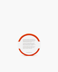 A round orange coaster by graf lantz features text on the white surface offering historical coaster info and web links. The edge is bordered with fine German Merino wool.