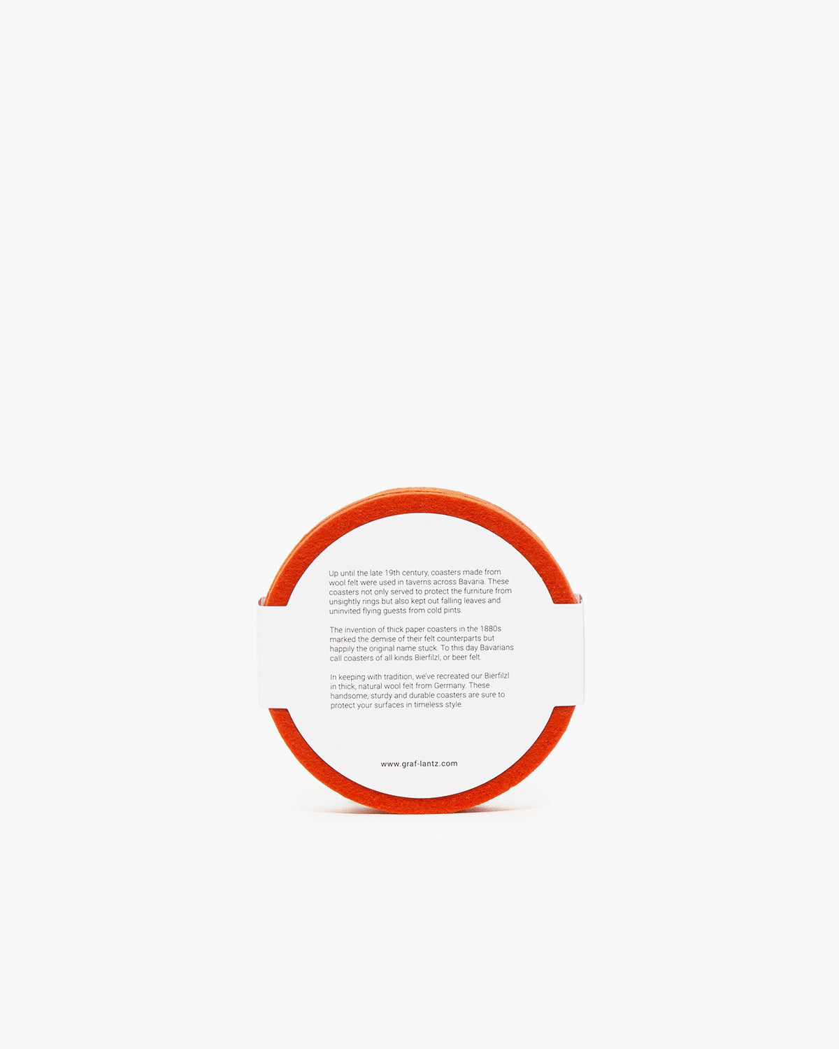A round orange coaster by graf lantz features text on the white surface offering historical coaster info and web links. The edge is bordered with fine German Merino wool.