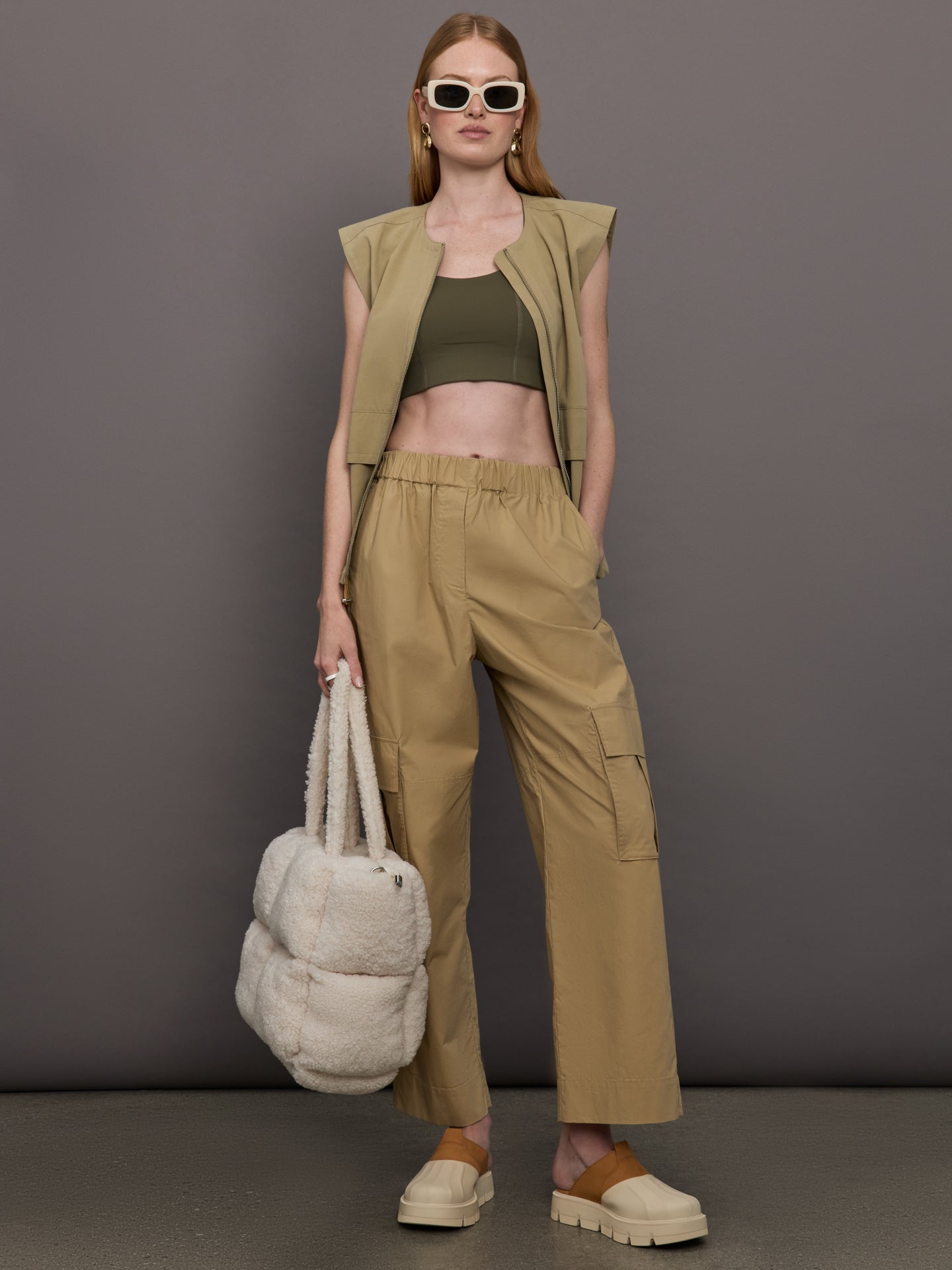 Model wears a pair of mid rise khaki cargo wide leg pants.