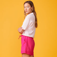 Side view of model wearing the polo sweater tee in bubble gum. 