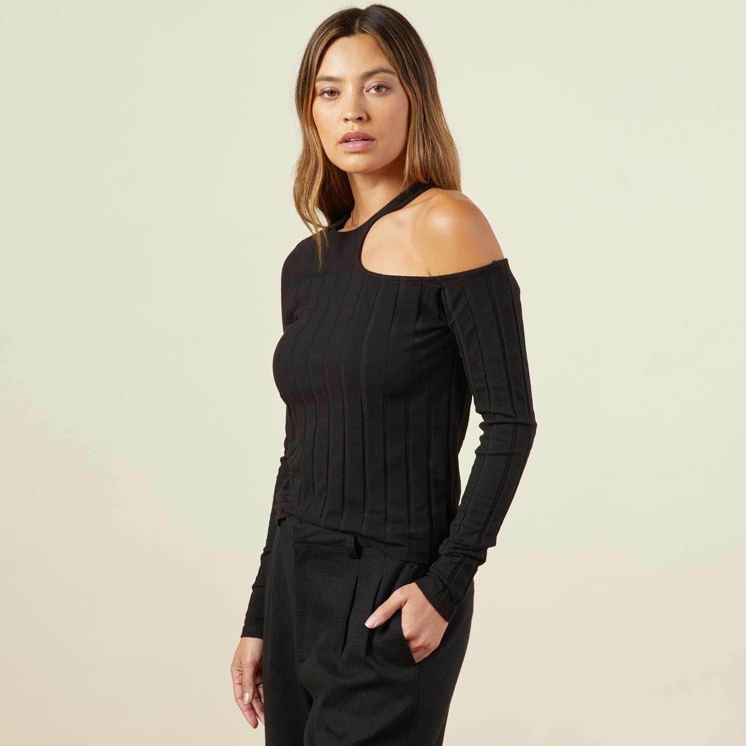 Side view of model wearing the flat rib asymmetric long sleeve in black.