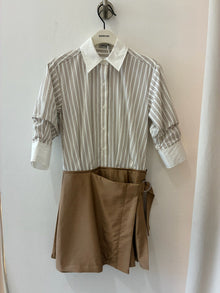 Striped button-up shirt with white collar and cuffs paired with tan wrap skirt on hanger.