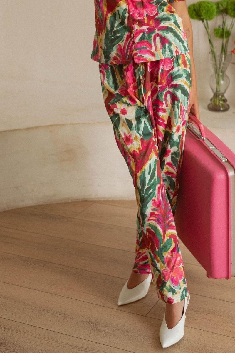 Wide-leg pants with pink, red, and yellow floral print on cream background, tapered ankle openings.