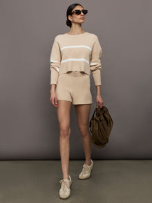 Model wears a pair of high rise khaki soft shorts. 