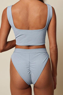 Light blue textured bikini bottom with high-cut legs and ruched center detail, shown from back view.