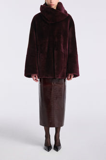Model is wearing Nour Hammour Lodge Decadent Shearling Pull Cassis - Front