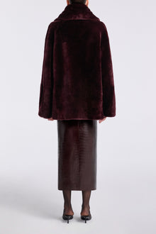 Model is wearing Nour Hammour Lodge Decadent Shearling Pull Cassis - Back