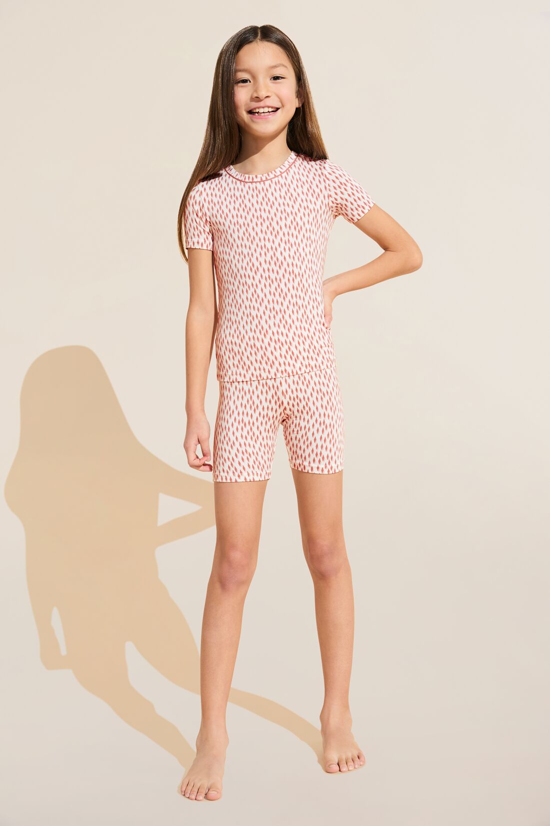 Model wears Kids Printed TENCEL™ Modal Unisex Short PJ Set in double diamond rouge pink.