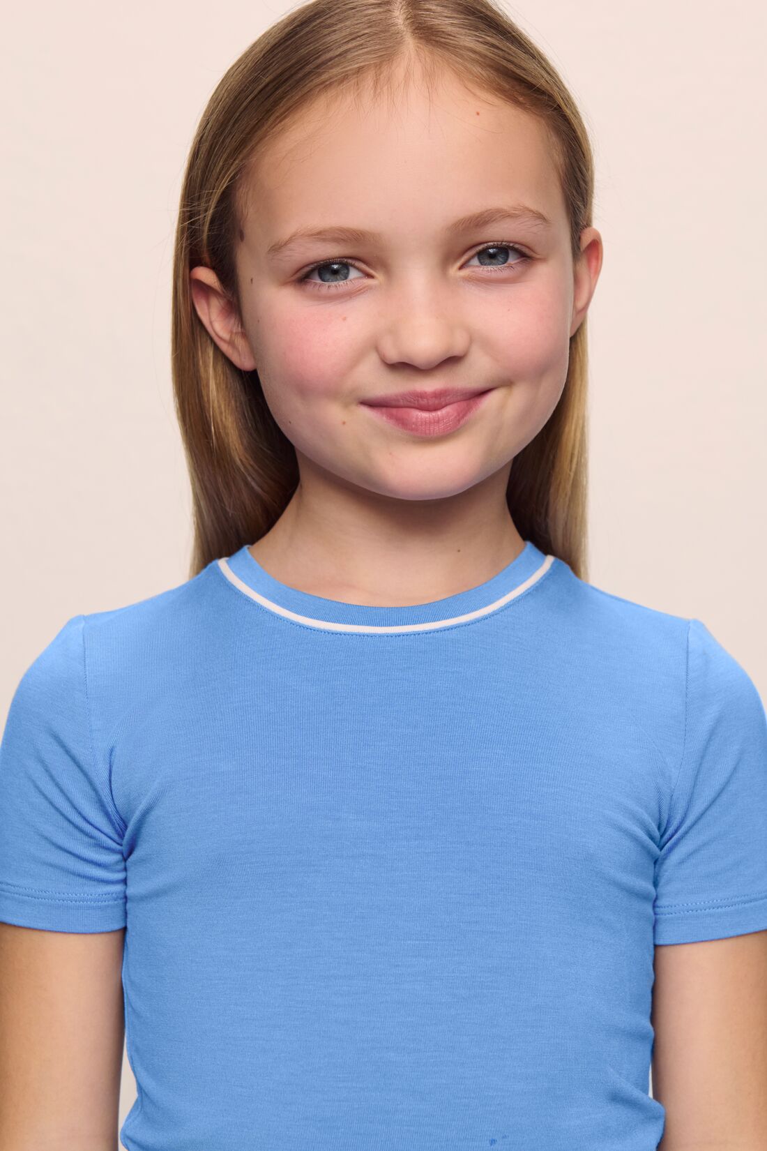 Model is wearing the Kids TENCEL Modal Unisex Short PJ Set in cornflower blue/white