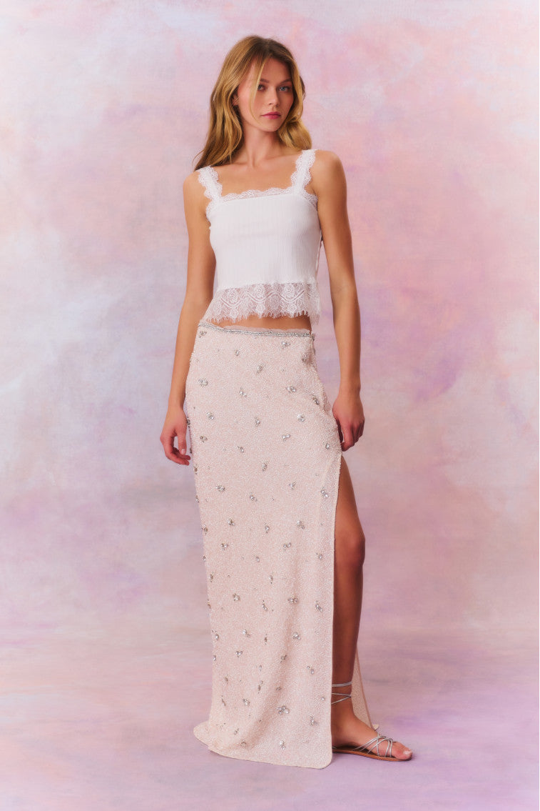 Maxi skirt featuring tiny beads that make up larger rhinestone-studded flowers dotting the skirt. Includes a side seam zipper and is finished with a slit at the wearer's left.