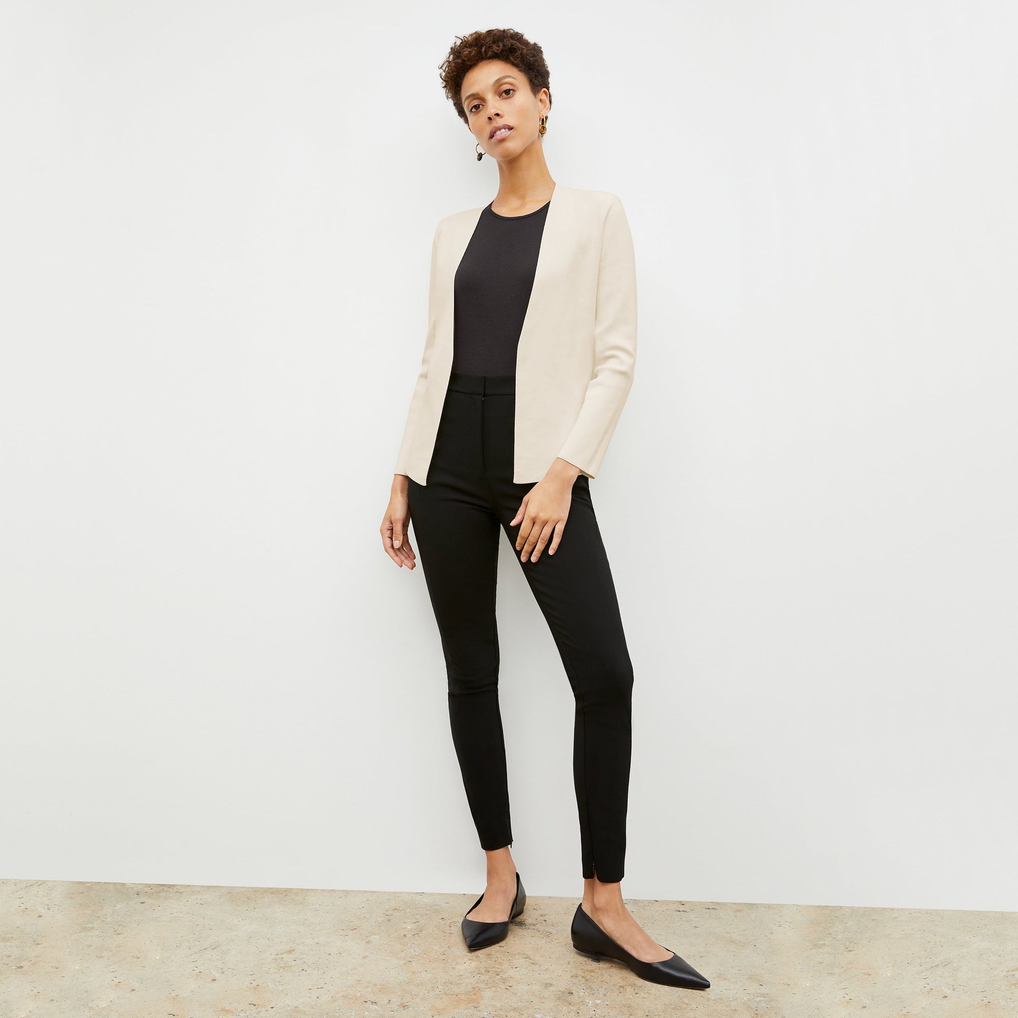 Front image of a woman standing wearing the curie pant in black | Exclude
