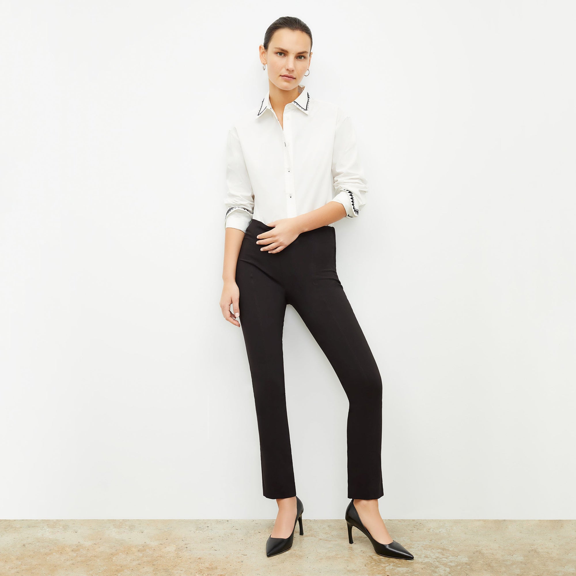 Front image of a woman standing wearing the Foster Pant—Everstretch in Black | Exclude