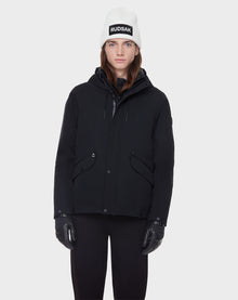 A person stands facing forward wearing the Rudsak DEST - CA EN 6119516 BLACK down jacket, black pants, black gloves, and a white beanie with 