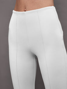 Close-up of white flare pants waistband and front seam detail.