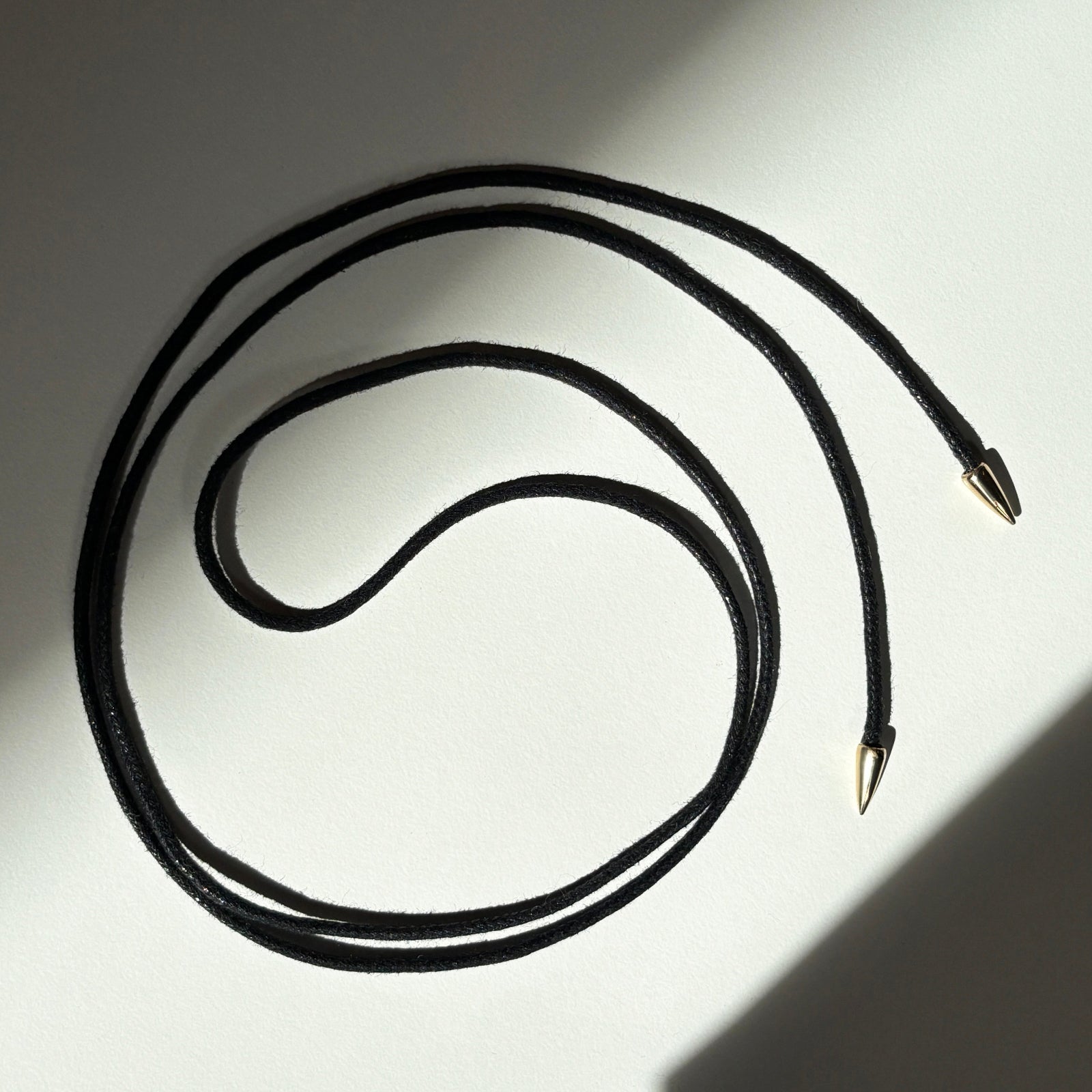 Quill cording in yellow gold on a white background.