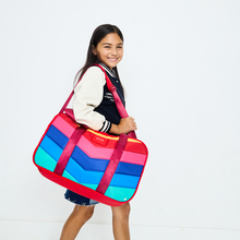 Girl wearing STATE Bags Rockaway Duffle Rainbow Chevron